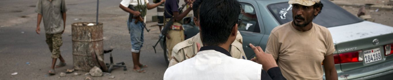 MSF team in Aden's streets. An MSF staff is speaking with armed men at a check point.