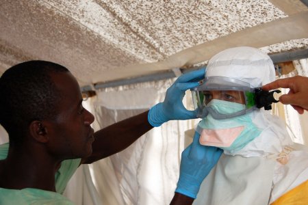 Une femme enfile une combinaison pour traiter les patients atteints par le virus ebola