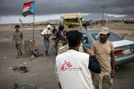 MSF team in Aden's streets. An MSF staff is speaking with armed men at a check point.
