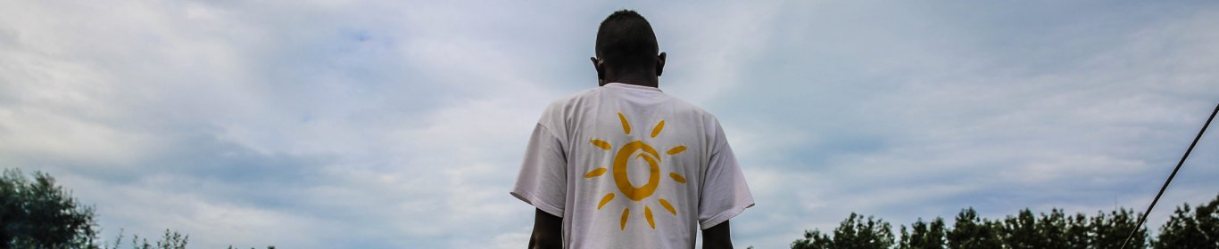 Un homme est debout devant les tentes d'un camp de réfugiés