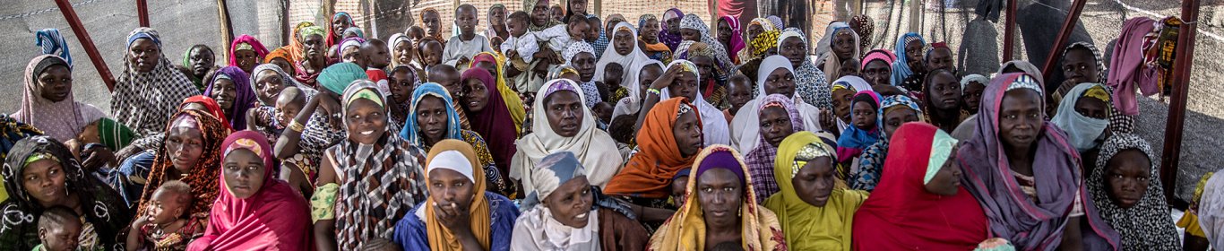 Des femmes sous un abri dans un camp de réfugiés