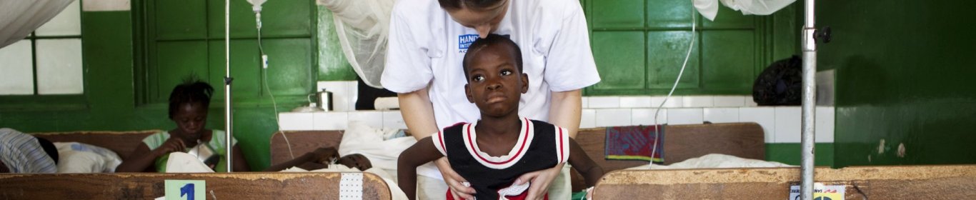 Handicaps et Médecine Un travailleur MSF aide un enfant qui a perdu une jambe à se tenir debout