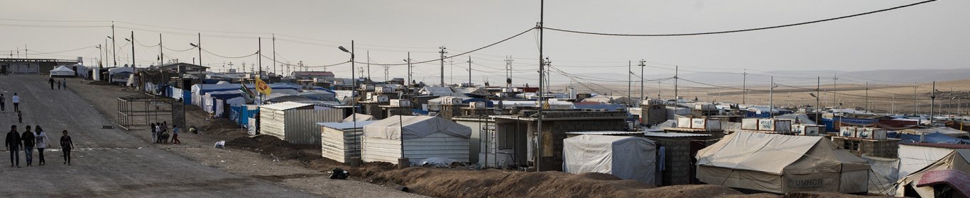 Une femme et deux enfants traversent une route dans le camp de réfugiés de Domiz, au Kurdistan Irakien