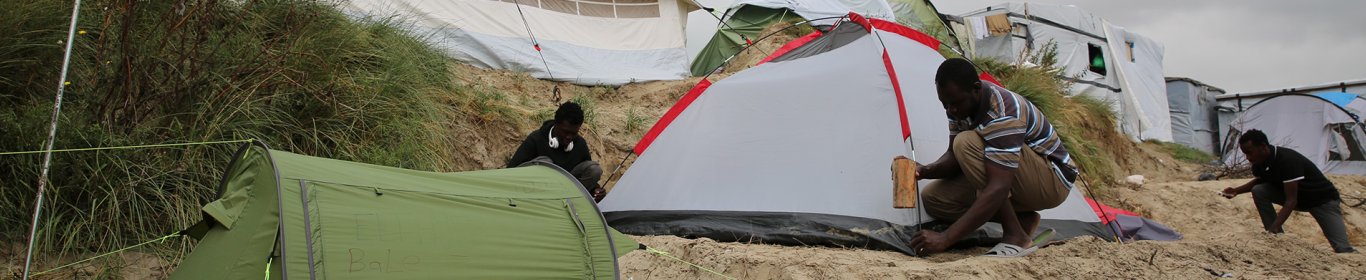 Un homme installe une tente dans la jungle de Calais, en septembre 2016