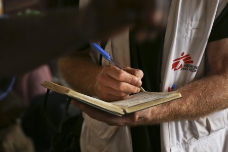 Un membre de MSF prend des notes dans un cahier