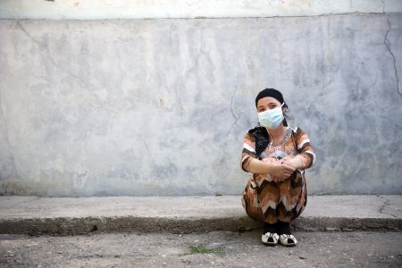 Jeune fille atteinte de tuberculose assise sur le bord de la route