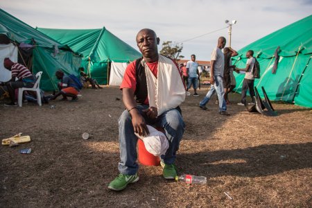 Un homme est assis au milieu du camp de réfugiés de Durban