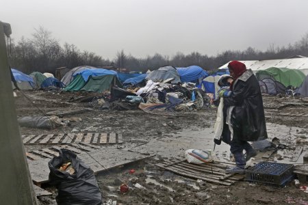 Une femme porte un enfant dans le camp de Grande Synthe