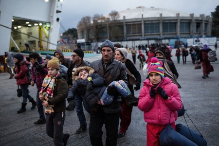 Migrants and refugees wait to board on a ferry to Athens, in the port of Mytilene