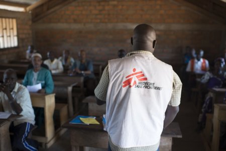 Un travailleur humanitaire MSF est face à plusieurs personnes dans une salle