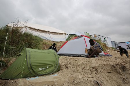 Un homme installe une tente dans la jungle de Calais, en septembre 2016