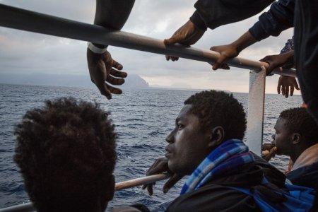 A bord du bateau Prudence, un groupe de migrants regarde les côtes siciliennes.