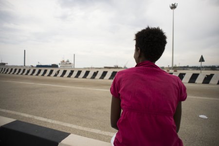 Une femme érythréenne regarde le port d'Augusta, en Italie